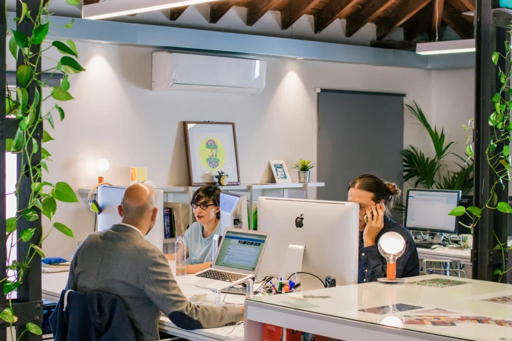Échanges professionnels dans un bureau, en face à face et au téléphone, pour illustrer la gestion des réclamations clients